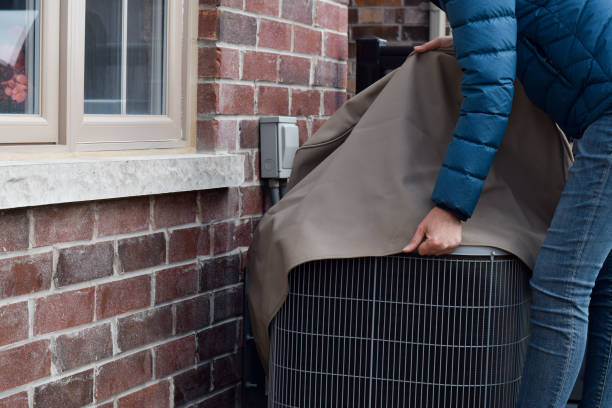 HVAC technician inspecting an outdoor air conditioning unit